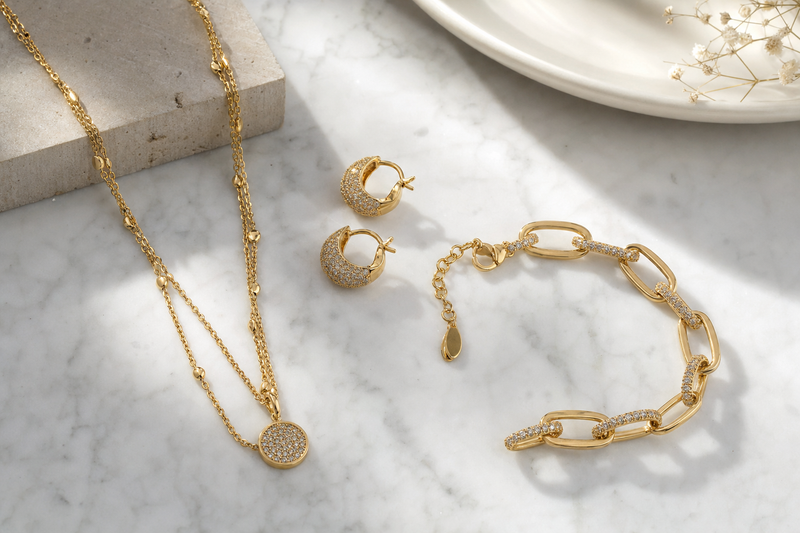 Luxury women's jewellery flatlay, gold necklace, earrings and bracelet on white marble background, soft natural light, premium editorial style