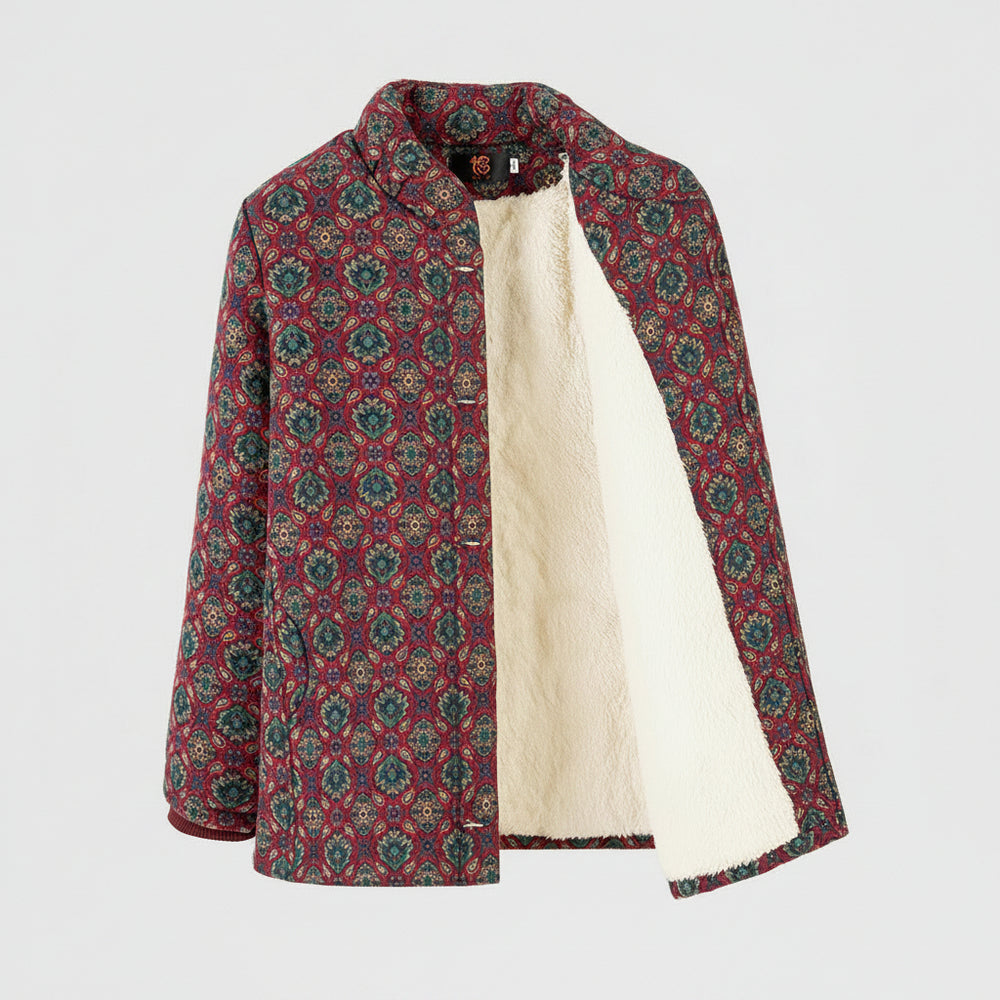 A women's quilted jacket with a red, green, and beige geometric pattern, featuring a soft cream fleece lining, shown on a hanger against a white background.