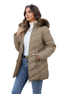 A woman models a mid-length quilted puffer coat in taupe brown with a faux-fur trimmed hood. She is wearing a white mock neck top, blue jeans, and sunglasses on her head against a plain white studio background.