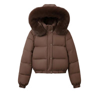 A brown puffer jacket with a large brown faux-fur trimmed hood, hanging on a wooden hanger against a plain light gray wall.
