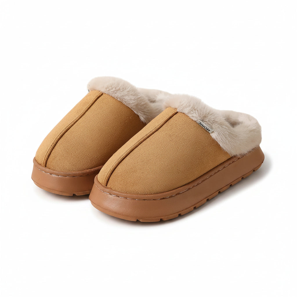 A pair of slip-on winter slippers in tan suede with a soft white faux-fur trim and a brown sole, shown on a plain beige background.