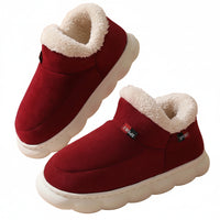 Red winter boots with white fur lining on a beige background