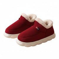 Red winter boots with white fur lining on a beige background