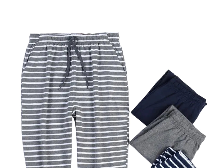 Gray and white striped lounge pants laid flat on a white background, styled with folded navy, gray, and striped pants, plus printed papers and a small white frame.