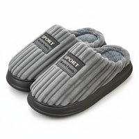 Gray slippers with 'Sport Warm Family' label on a wooden floor.