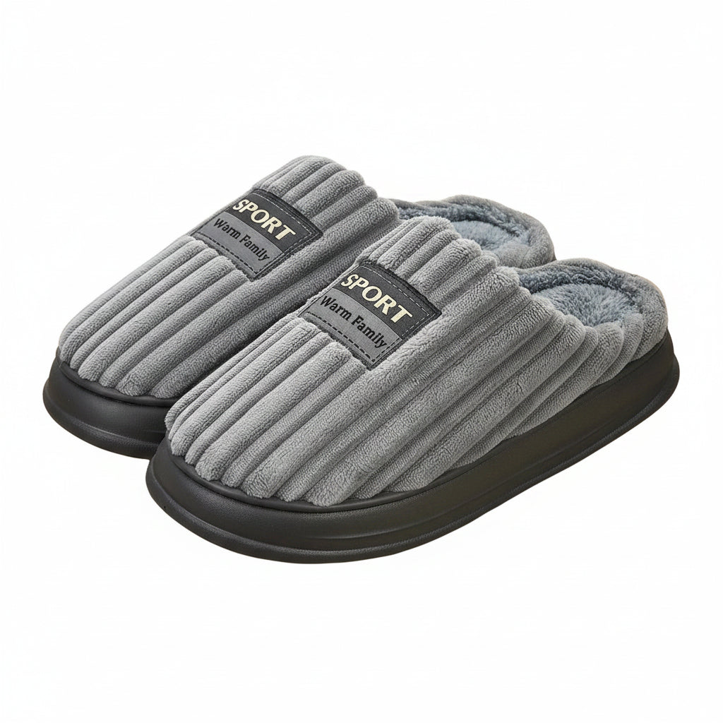 Gray slippers with 'Sport Warm Family' label on a wooden floor.