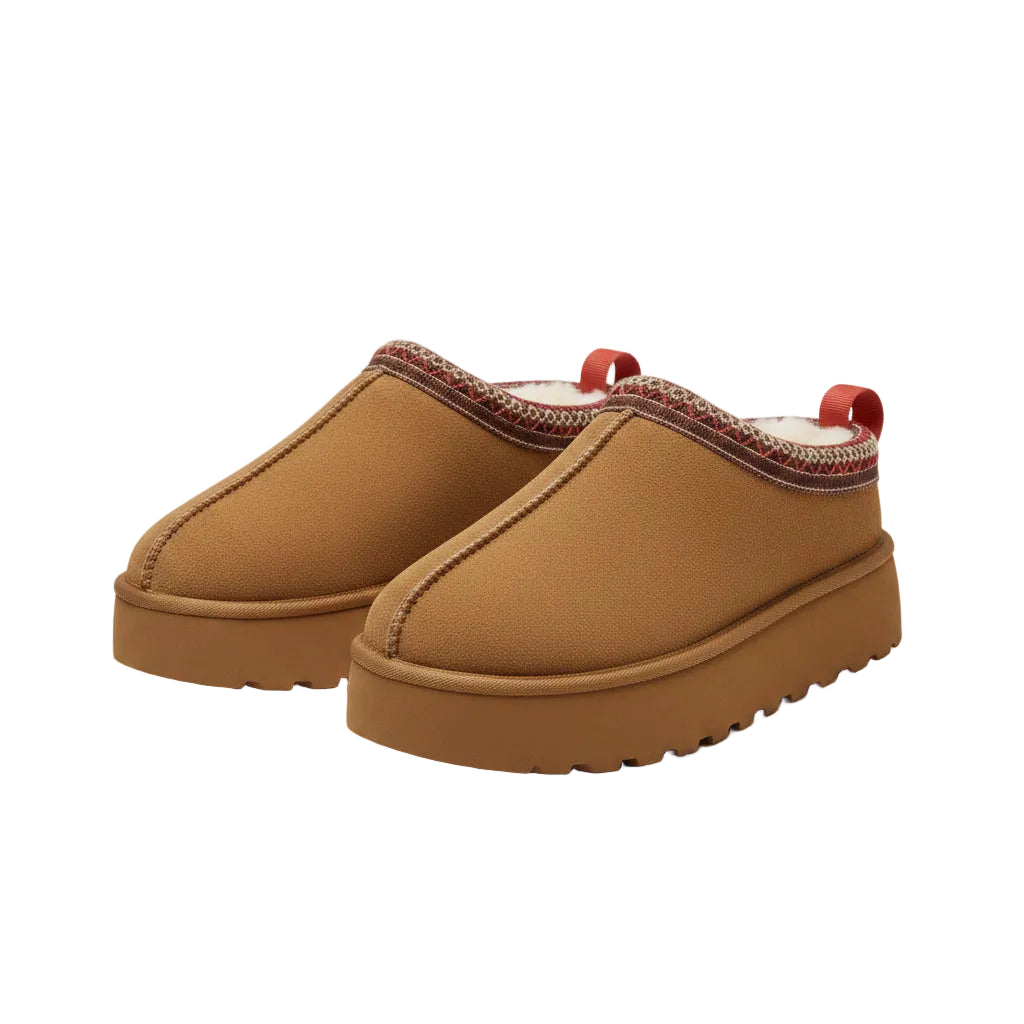 Brown slippers with red accents on a fluffy white surface