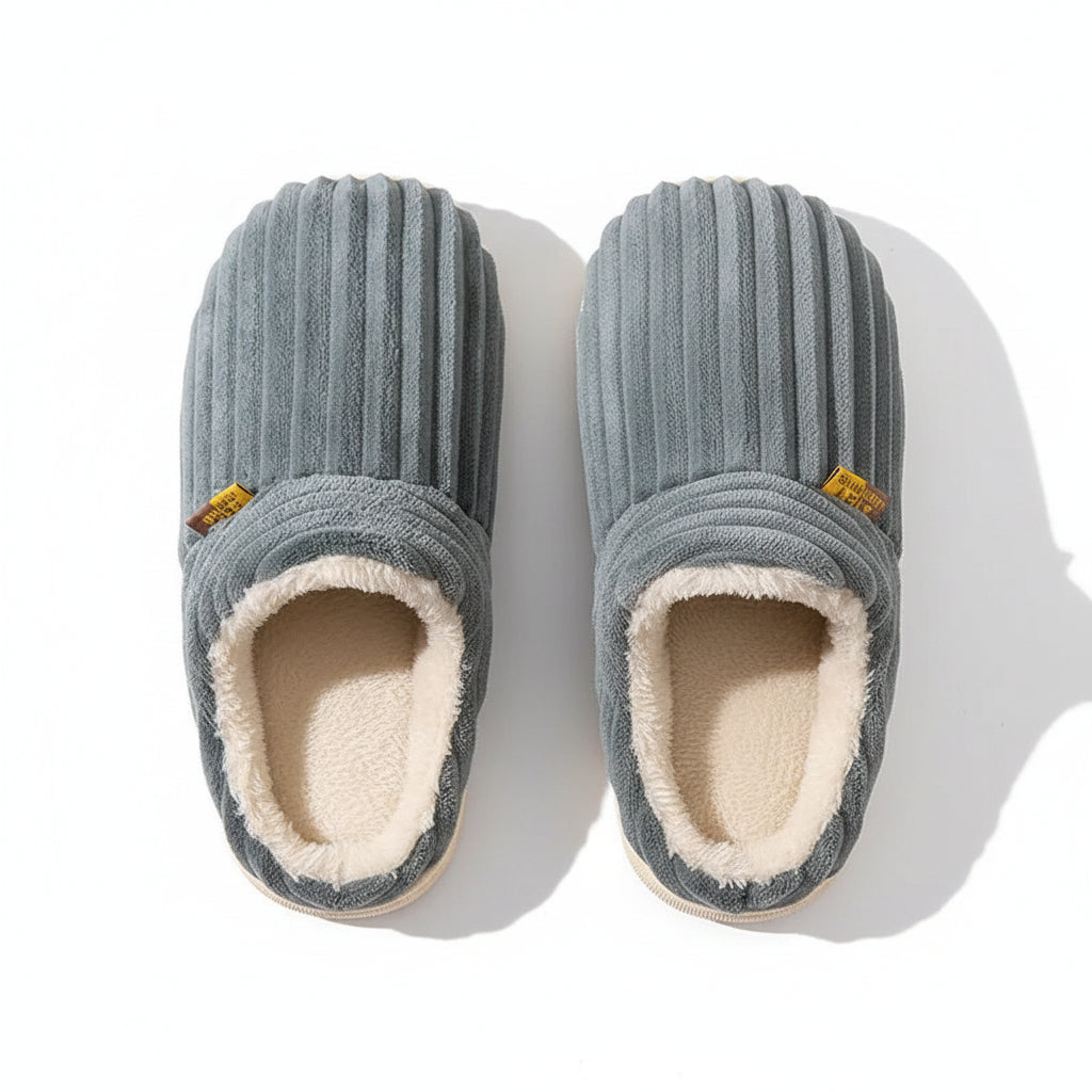 Pair of gray slippers with a textured surface on a brown background