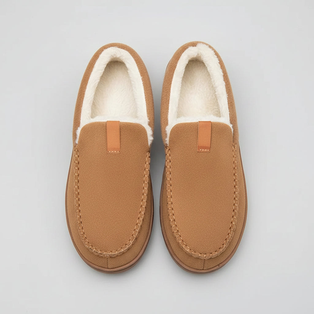 Pair of brown slippers with white fur lining on a wooden floor.
