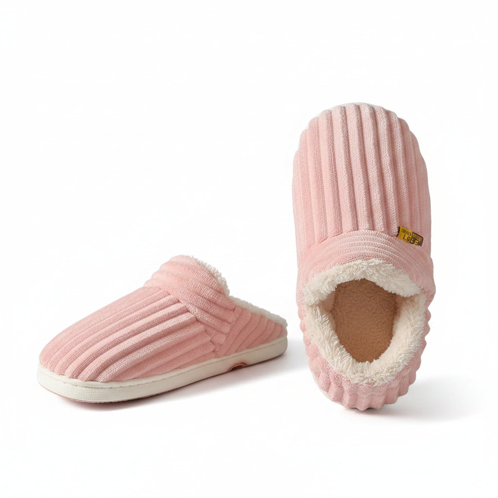 Pink slippers being held against a brown background