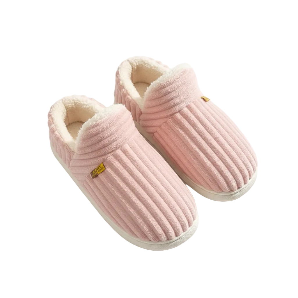 Pair of gray and pink slippers on a wooden floor with a person wearing them.