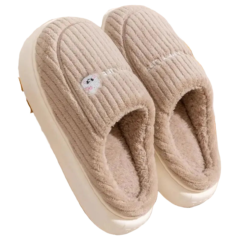 Pair of beige slippers on a wooden rack with a soft texture.