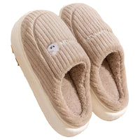 Pair of beige slippers on a wooden rack with a soft texture.