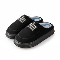 Black slippers with blue lining on a wooden floor