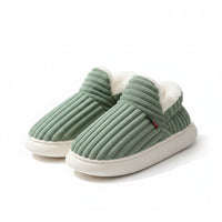 Green slippers with white fur lining on a light background