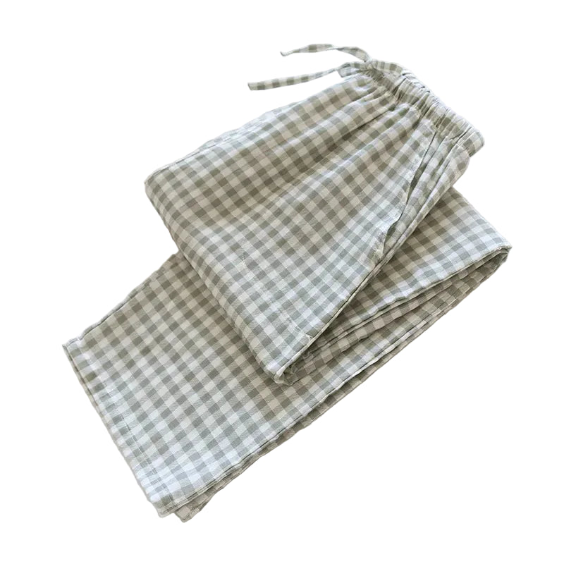 Green and white checkered fabric on a white surface with a book underneath