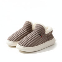 Pair of gray slippers with white soles on a light background