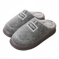Gray slippers with 'Journal' label on a wooden floor