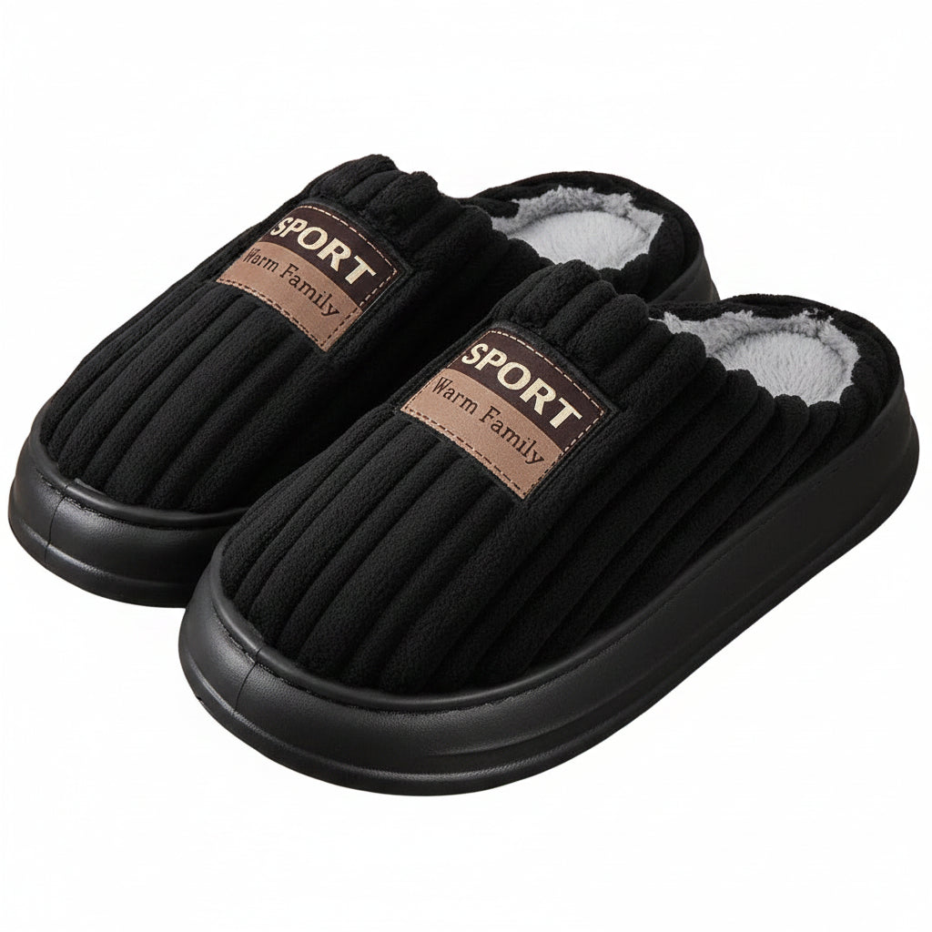 Black slippers with brown labels on a wooden floor