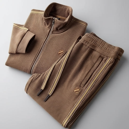 Folded brown corduroy jacket and pants set on a gray background