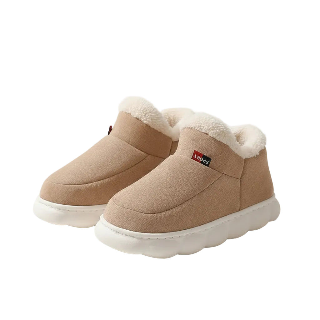Pair of beige winter boots with white soles on a light background