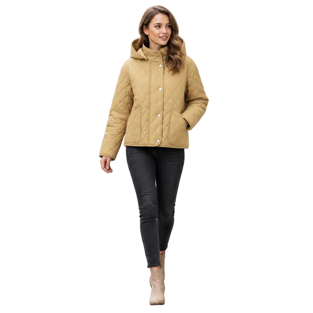 A woman walking on a city sidewalk wearing a quilted hooded jacket in camel beige, paired with dark skinny jeans and beige ankle boots.