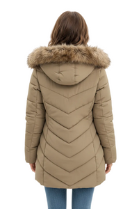 A woman viewed from the back wearing a beige puffer coat with a fur-trimmed hood and chevron quilting, paired with blue jeans against a plain light background.
