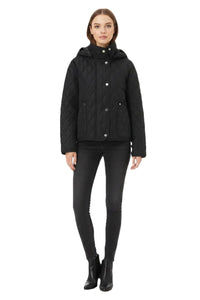 A woman modeling a black quilted hooded jacket with snap buttons, paired with black skinny pants and black ankle boots, against a plain white background.