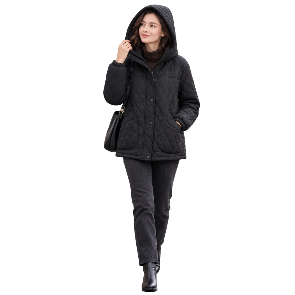 A woman walking on a wet city street wearing a black quilted hooded jacket, dark pants, and black ankle boots, with a blurred classical building in the background.