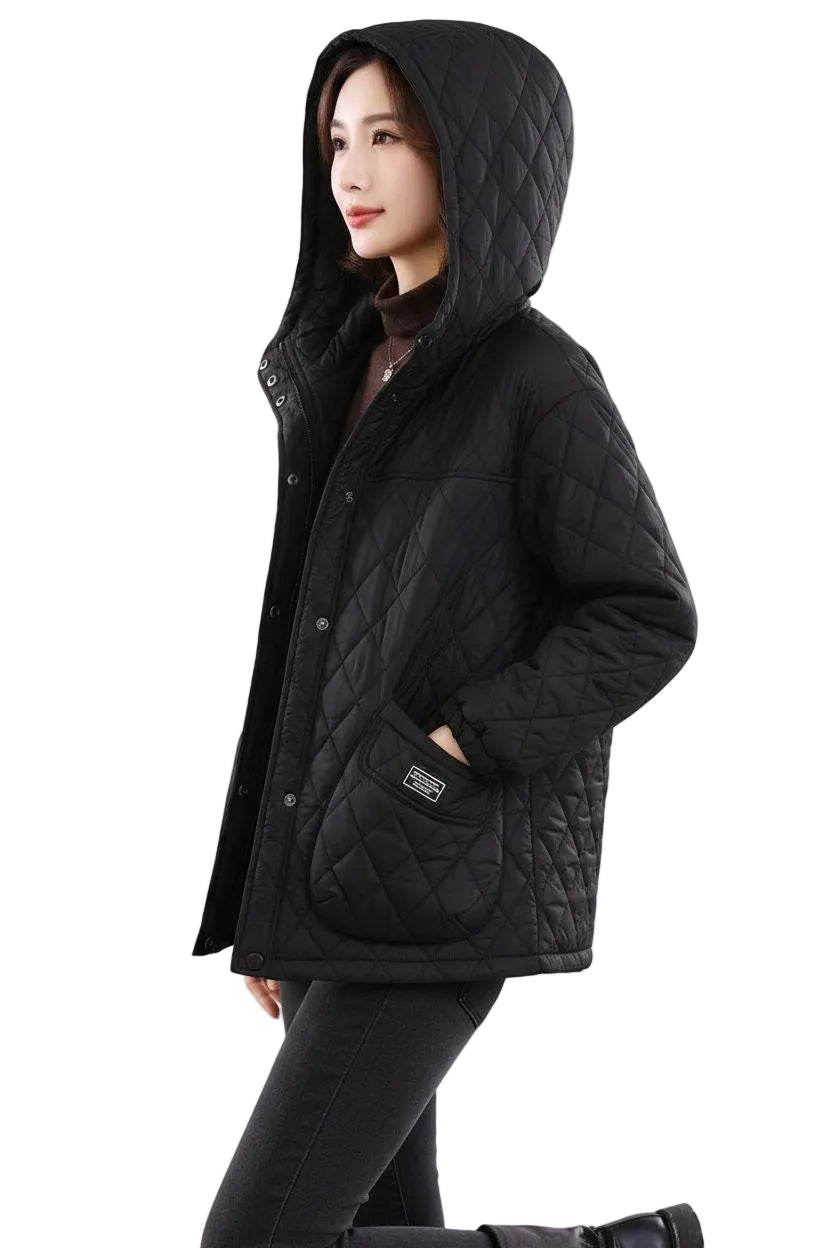 A woman wearing a black quilted hooded jacket with a high collar, front snap closure, and a large front patch pocket, shown against a plain white background.