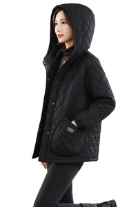 A woman wearing a black quilted hooded jacket with a high collar, front snap closure, and a large front patch pocket, shown against a plain white background.
