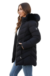 A woman wearing a black puffer coat with a dark fur-trimmed hood, paired with a white top and blue jeans, shown in profile against a plain white background.