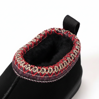 Close-up of a black winter boot showing the interior lining and decorative stitching around the collar, with a black pull tab at the top, on a white background.