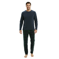 A man modeling a two-piece pajama set consisting of a dark navy long-sleeve shirt and green plaid pajama pants, standing against a plain white background.