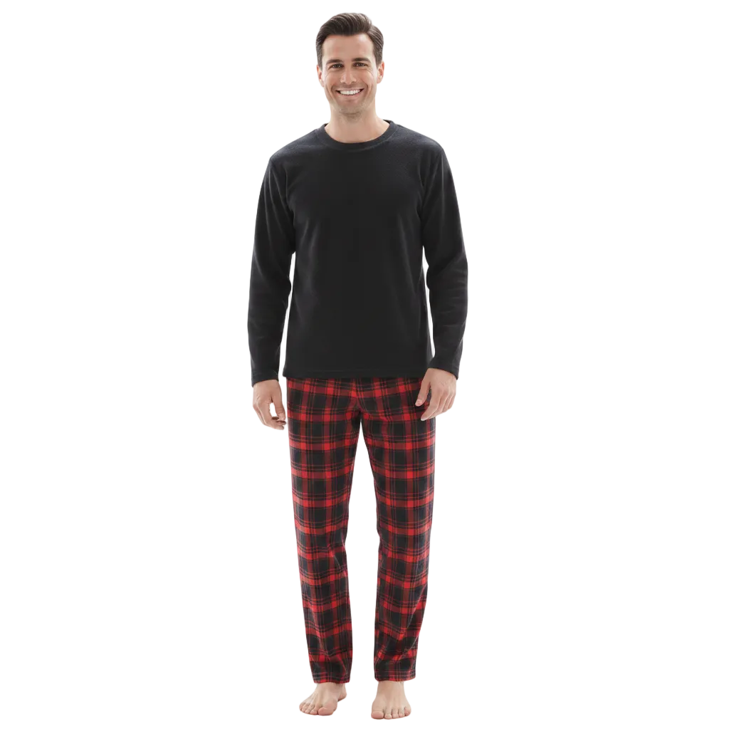 A man wearing a black long-sleeve shirt and red and black plaid pajama pants, standing against a plain white background.