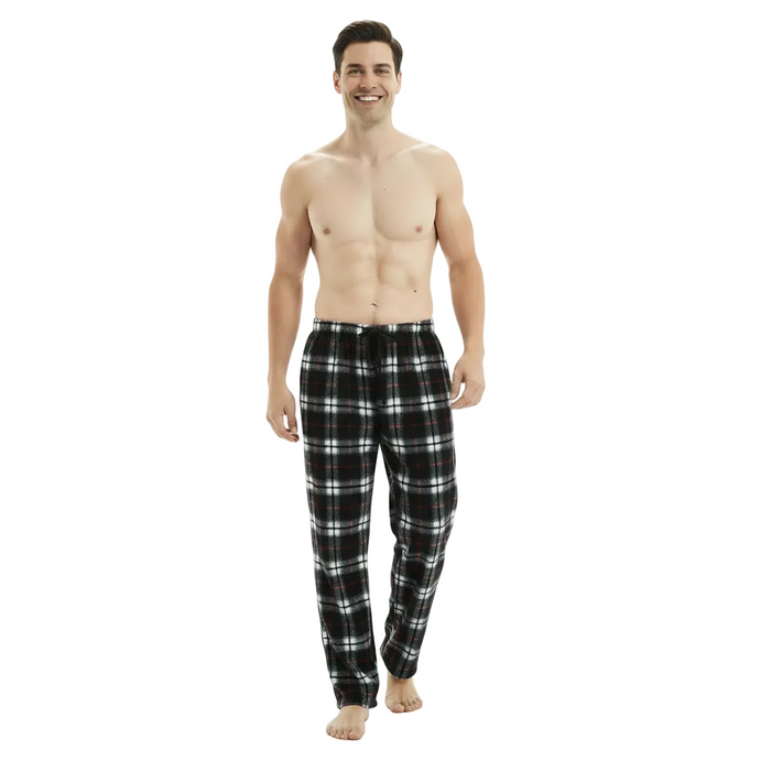 A man modeling black and white plaid pajama pants against a plain white studio background.