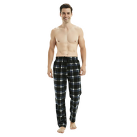 A man modeling a pair of black plaid pajama pants with blue and white stripes, standing against a plain white background.