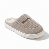 A single taupe ribbed knit slipper with a white sole and cream sherpa lining, featuring the embroidered brand name 'Happy Paws' on the side, set against a clean white background.