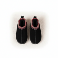 A pair of black slip-on slippers with a red and white patterned trim around the collar, shown from a top-down view on a white background.