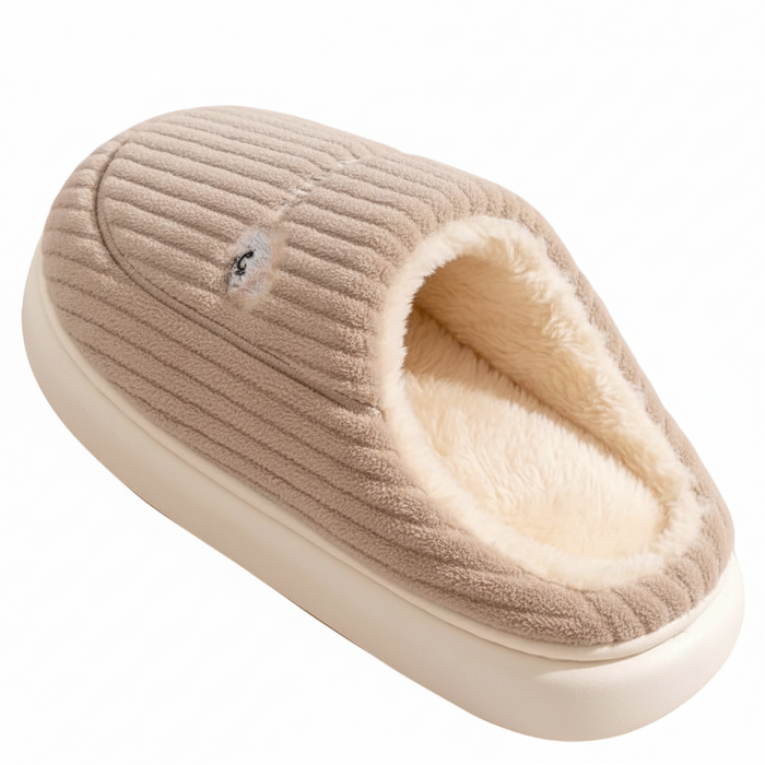 A single slip-on indoor slipper in a warm beige corduroy-like fabric with a soft cream fleece lining and a thick cream sole, shown on a plain white background.