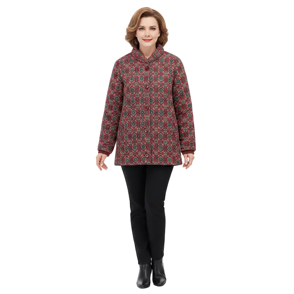 A woman modeling a quilted jacket with a red, green, and black geometric pattern, paired with black pants and black boots, against a solid white background.