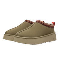 A pair of slip-on platform mule shoes in a muted olive-tan color, featuring a decorative red and beige patterned collar trim and a red pull tab.