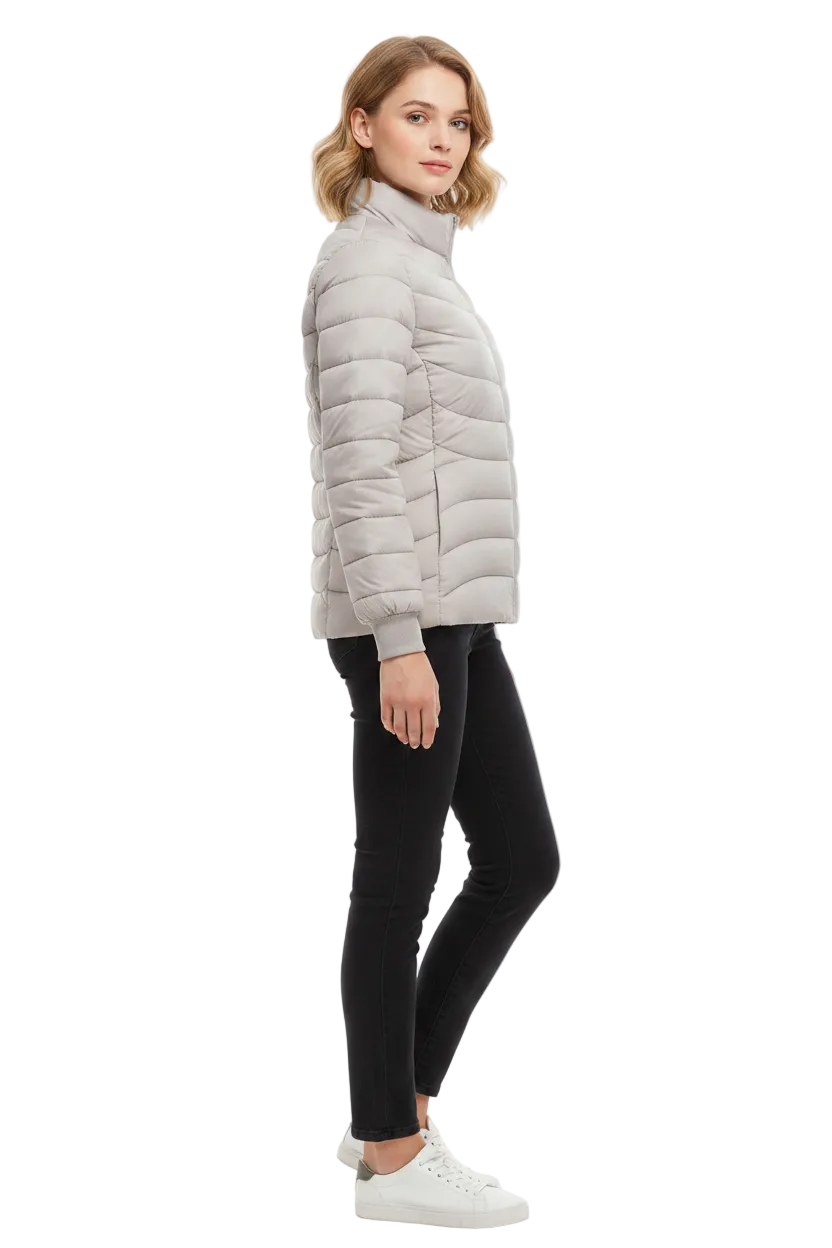 A woman modeling a light gray puffer jacket, paired with black skinny jeans and white sneakers, shown from a side profile against a plain white studio background.