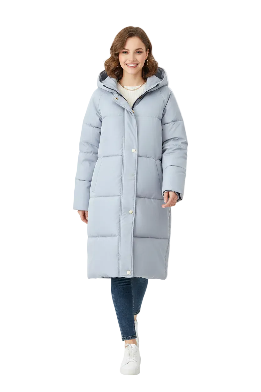 A woman modeling a long, light blue-gray hooded puffer coat with front buttons, worn over a cream top, dark blue jeans, and white sneakers, against a plain white studio background.