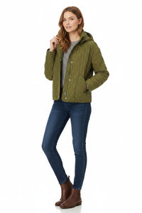 A woman modeling an olive green quilted hooded jacket, paired with a gray top, dark blue skinny jeans, and brown ankle boots, against a plain white background.