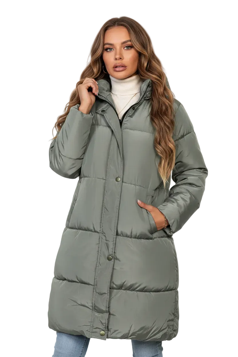 A woman modeling a long, sage green puffer coat over a white turtleneck and light blue jeans, photographed against a clean white studio background.