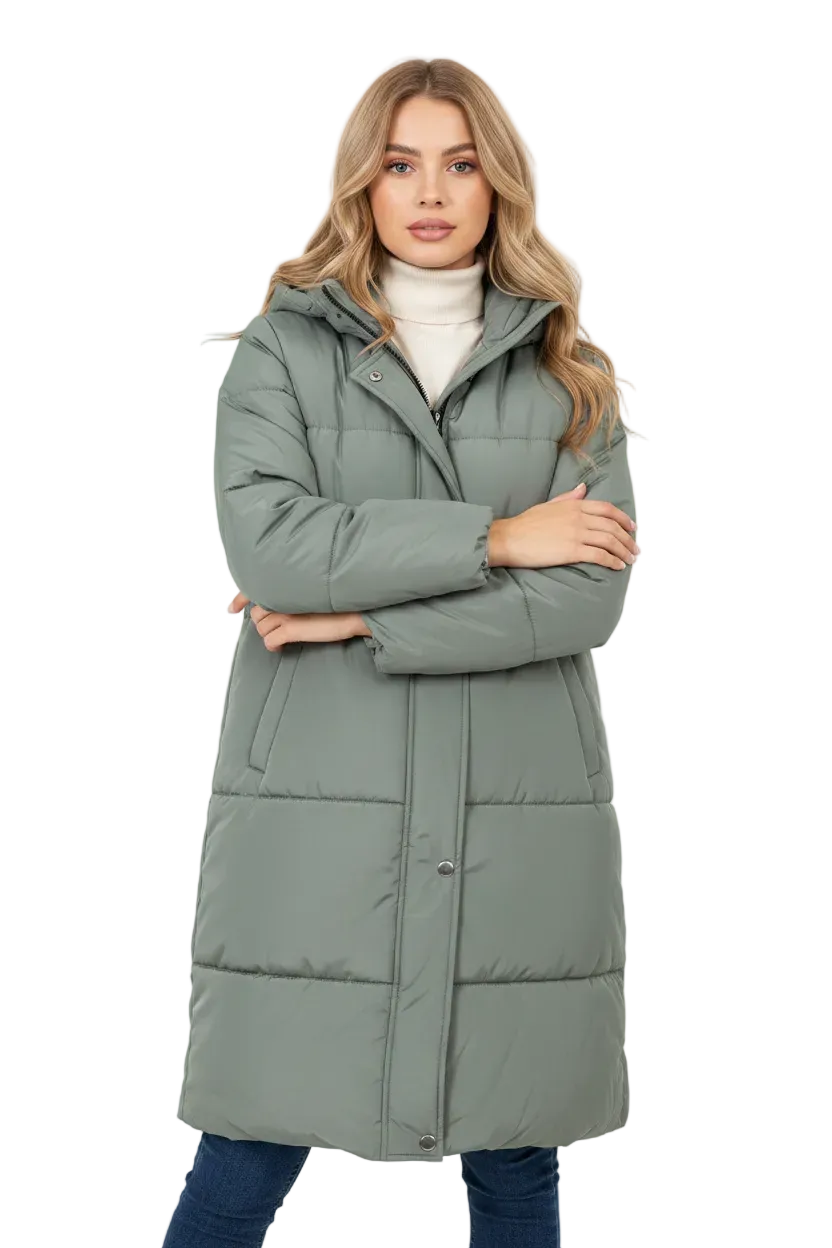 A woman modeling a long, sage green puffer coat over a white turtleneck sweater and blue jeans, standing against a plain white studio background.
