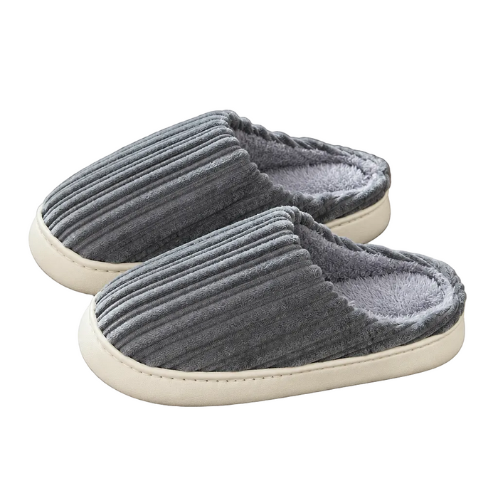 A pair of gray corduroy slip-on slippers with a soft gray fleece lining and cream-colored soles, shown on a clean white background.