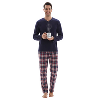 A man wearing a navy blue long-sleeve V-neck pajama shirt with a graphic print and matching plaid pajama pants, holding a mug that says 'COFFEE WOMAN' against a plain white background.