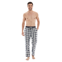A man modeling a pair of plaid pajama pants with a black waistband, standing against a solid white background.